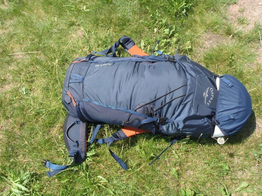 Kompletně nabalený batoh Osprey Mutant 38 včetně nasazeného víka a síťky na helmu.