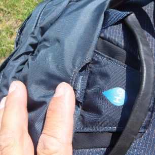 Sponu na zatahování batohu se shora (fixace lana) je možno schovat do kapsičky u výstupu hadice na hydrovak - Osprey Mutant 38.