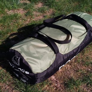 Zabalený stan NORDISK OPPLAND 3 PU v transportním vaku s madly a stahováním.