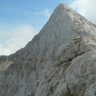 Výstup na Prisojnik vede náročnou feratou, která končí v obřím skalním okně. Julské Alpy, Slovinsko.
