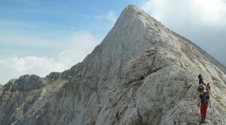 Výstup na Prisojnik vede náročnou feratou, která končí v obřím skalním okně. Julské Alpy, Slovinsko.