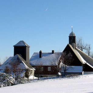 Zasněžené chalupy v Krušných horách