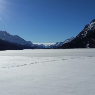 Během běžkování po zamrzlých jezerech se vám naskytnou krásné výhledy, jezero Silvaplana, Švýcarsko